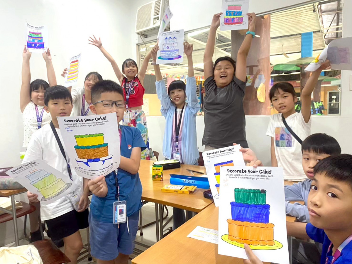 宿霧 BTES 語言學校營隊的美術課,孩子們高高舉起自己彩繪的「Decorate Your Cake!」蛋糕畫作歡呼