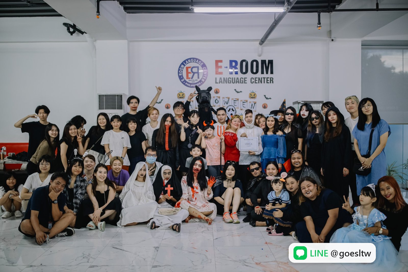 EROOM 萬聖節派對,大家在 E-ROOM 校名牆前合照