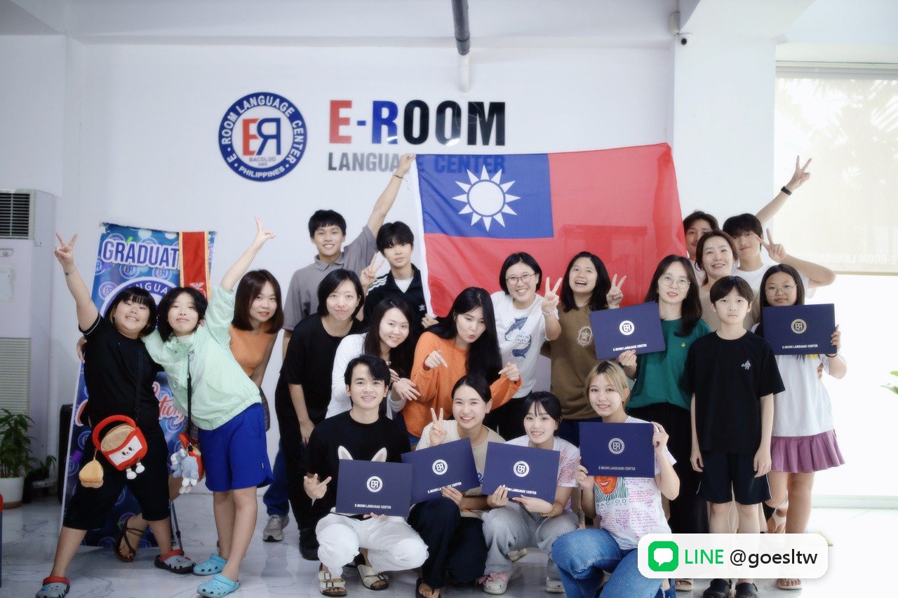 EROOM 學生拿著台灣國旗與證書,在 E-ROOM 校名牆前合照