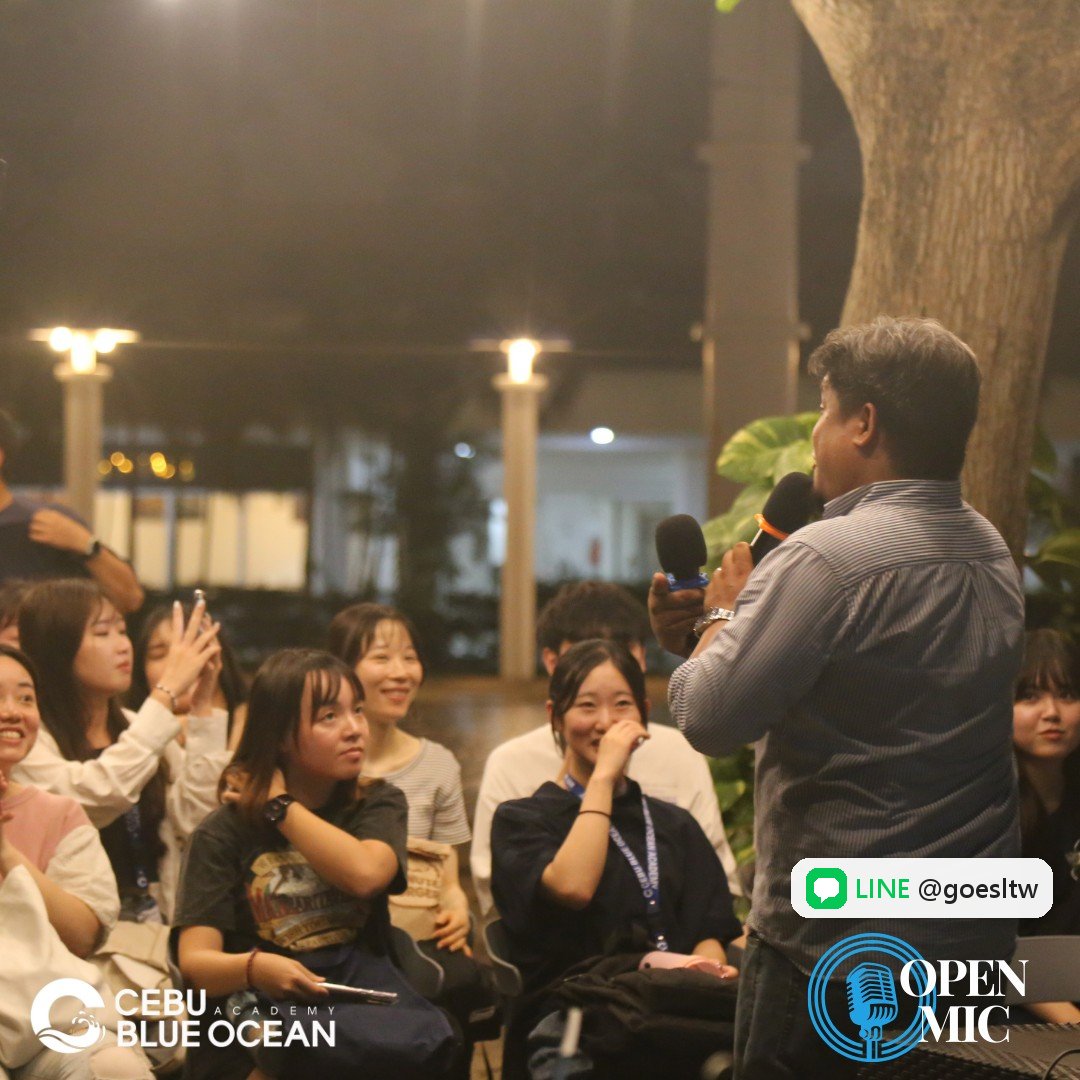 CBOA Open Mic 晚會,學生笑著聽拿麥克風的人分享