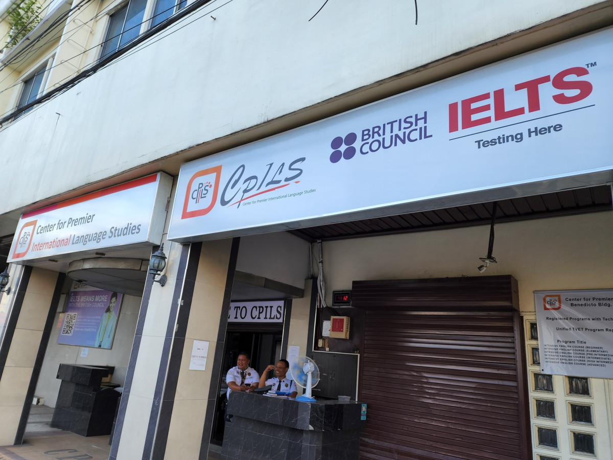 宿霧 CPILS 語言學校校門口,招牌上是英國文化協會和 IELTS Testing Here 字樣,下方是警衛亭