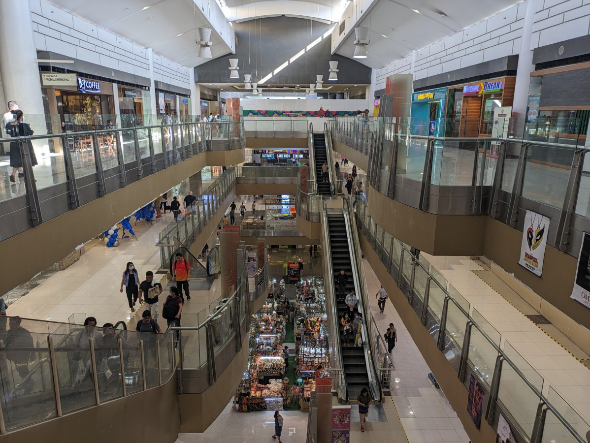 宿霧 CWA 附近的 SM City Cebu 商場,從樓上往下看挑高中庭、手扶梯和一層層店家,有逛街的人