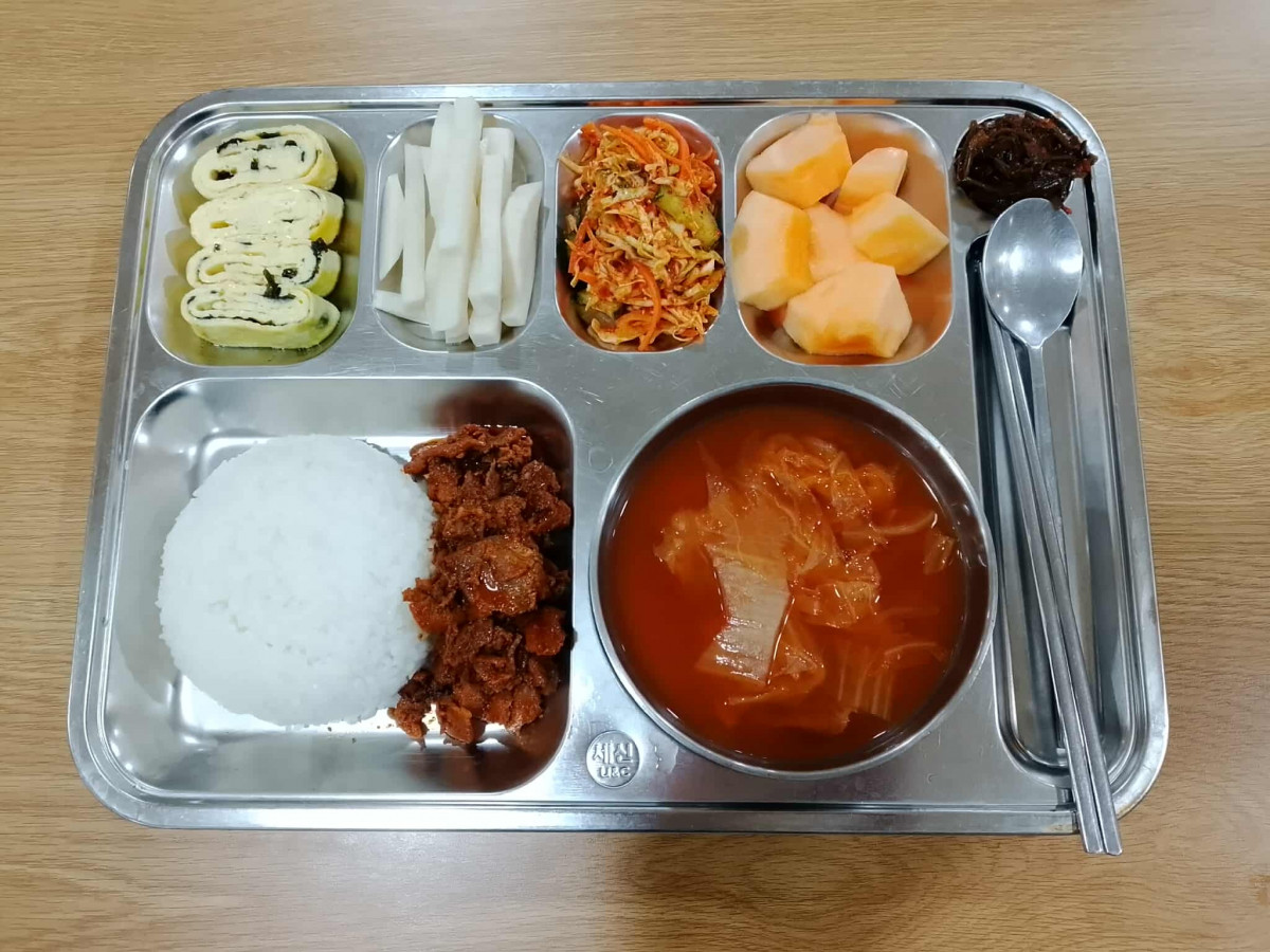 克拉克 GS 語言學校餐廳的一份韓式餐盤,有白飯、辣炒肉、泡菜湯、海苔蛋捲、白蘿蔔條和哈密瓜