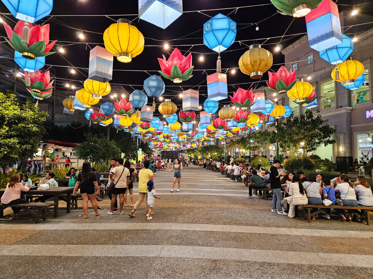怡朗 PIA 附近 K-Town 美食街的夜晚,步行街上方掛滿彩色燈籠,兩旁有座位和逛街的人