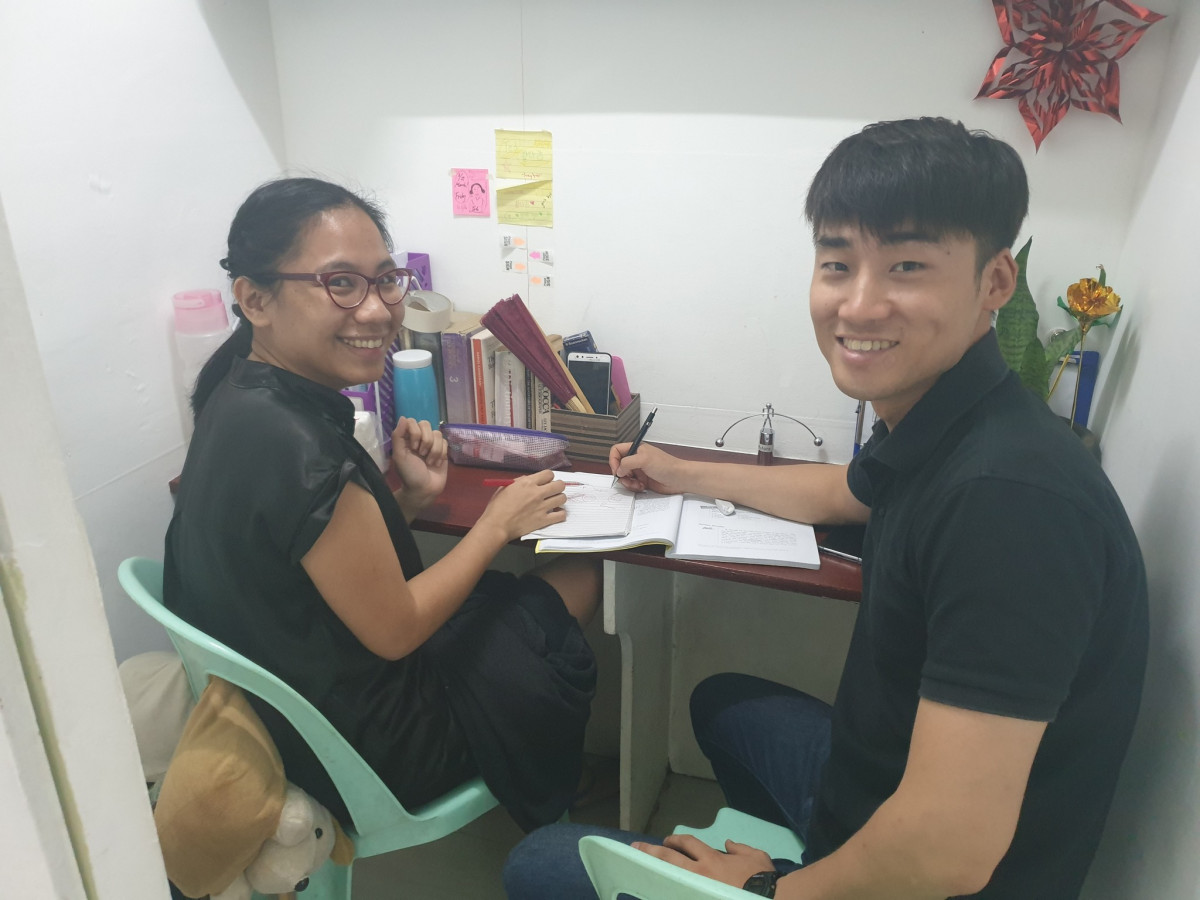 怡朗 WE 語言學校的一對一小教室,老師和學生坐在同一張書桌前上課,桌上攤著課本和筆記