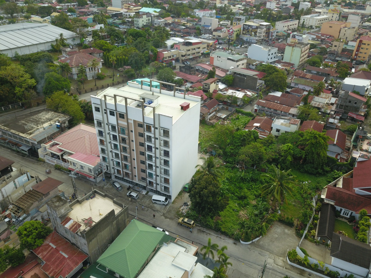 怡朗 WE ILOILO 語言學校校園空拍,白色校舍大樓四周是住宅區的屋頂和綠樹