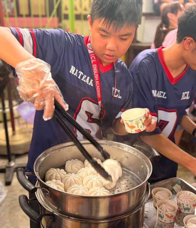 國際志工園遊會:ICL 學生在攤位夾蒸點心(往年營隊)